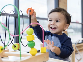 Como fomentar la independencia en bebés Niño feliz jugando jugando con juguete interactivo