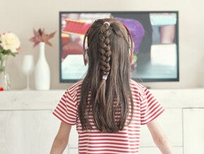 Niña pequeña viendo la televisión.