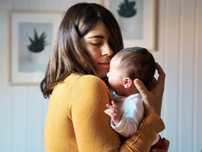 Mamá cargando a un bebé recién nacido.