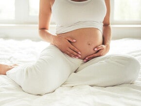 Conoce qué es el líquido amniótico y su función. Mamá tocando el vientre.