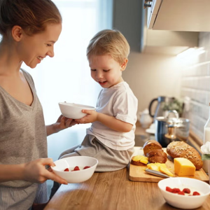 Alimentos energéticos clave para niños Madre y niño en la cocina, sentado en la mesada con un tazón, queso y pan, alimento energético.