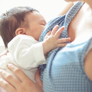 Cuidados posparto para Mamá Mamá en etapa de posparto, sosteniendo por el pecho a su bebé recién nacido.