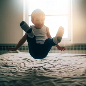 niño saltando sobre la cama