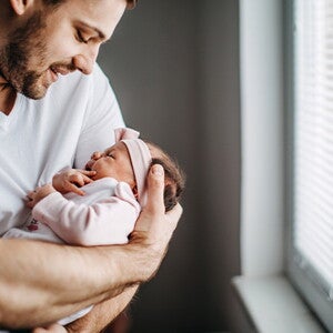 Papá alzando su bebé y revisando los granito de su cara