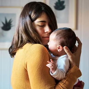 Mamá cargando a un bebé recién nacido.