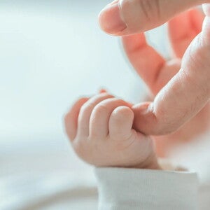 Bebé sujetando el dedo de su mamá