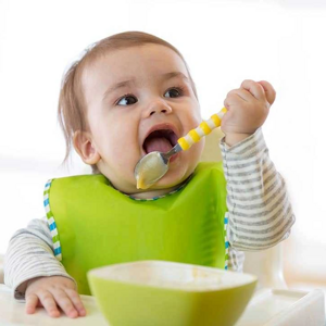 Bebé con babero comiendo