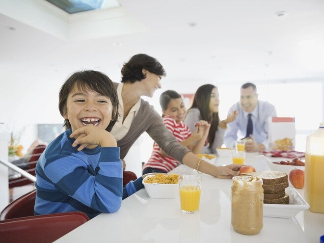 Familia el desayuno juntos en la cocina, sentados alrededor de la mesa.