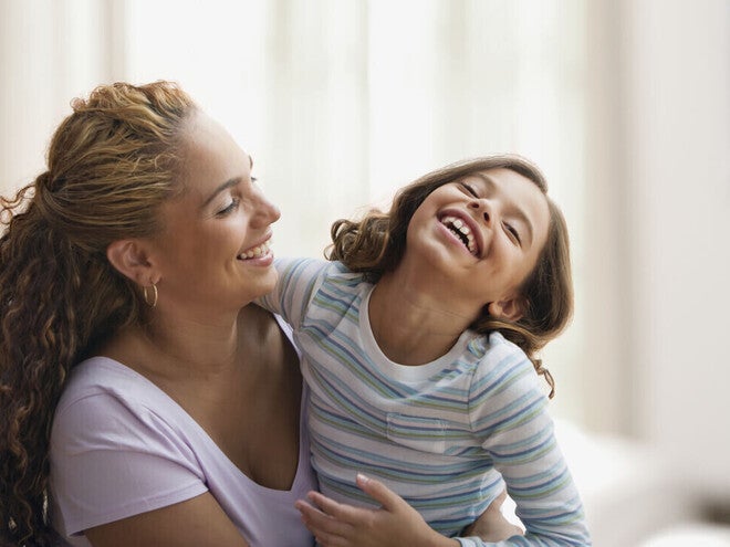 Mamá y niña de preescolar riendo al decir trabalenguas