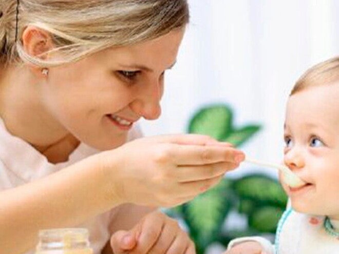 ¿Cómo debe ser la alimentación complementaria en bebés de 8 a 12 meses? Mamá dando de comer papilla a su bebé como parte de la alimentación complementaria.