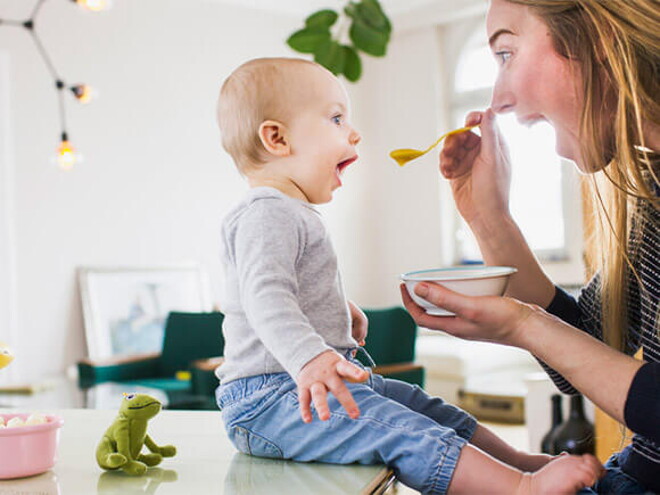 Conoce el desarrollo de tu bebé de 10 meses. Bebé de 10 meses sentado comiendo con mamá