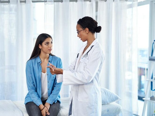 Mujer teniendo una consulta médica con la especialista en Fertilidad Mujer teniendo una consulta médica con la especialista en Fertilidad