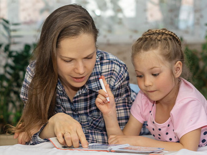 Conoce los diferentes estilos de aprendizaje. Mamá explicando a su hija por medio de un libro.