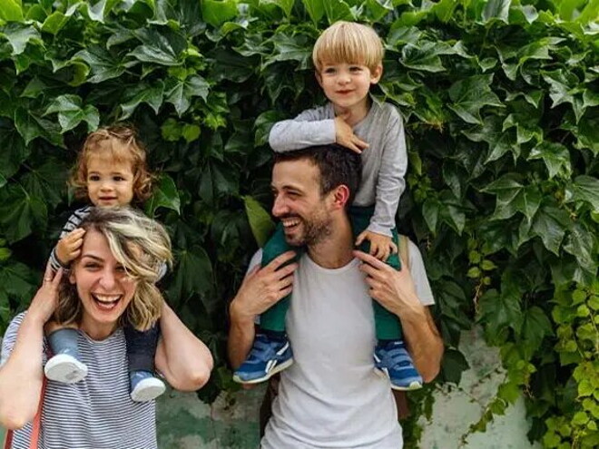 Feliz en brazos de papá y mamá.