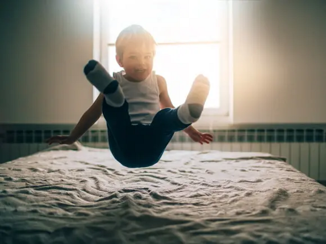 Estimulación temprana para bebés y niños niño saltando sobre la cama