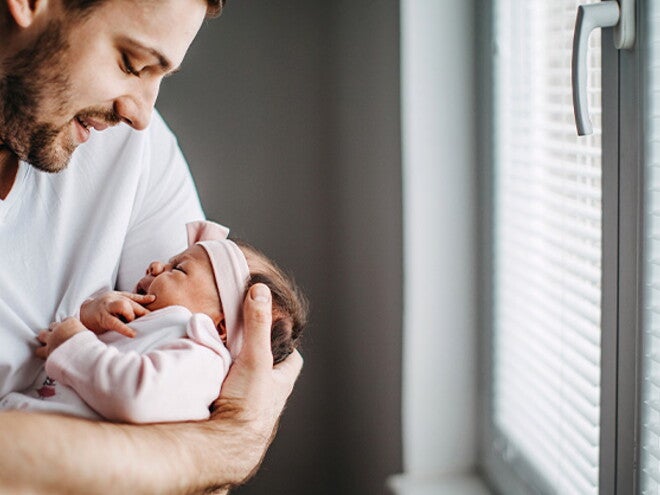 Los granitos en la cara de los bebés es un fenómeno común Papá alzando su bebé y revisando los granito de su cara