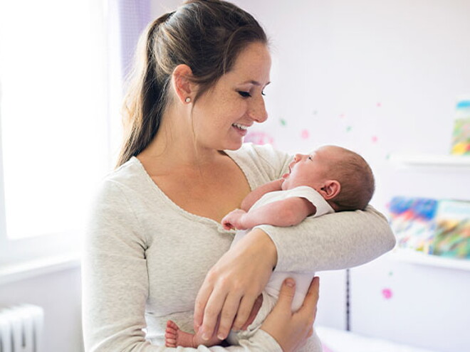 Conoce todo lo que debes saber si eres mamá primeriza. Mamá primeriza alzando en brazos a su bebé recién nacido.