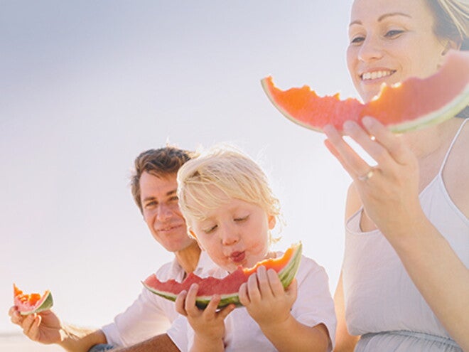 14 formas de criar a un niño con hábitos alimenticios saludables Familia comiendo sandía