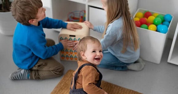 Niños pequeños riendo y jugando en un cuarto de juegos.