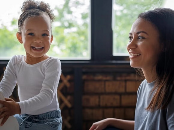 Madre y niña pequeña con Apraxia del Habla Infantil jugando y riendo.