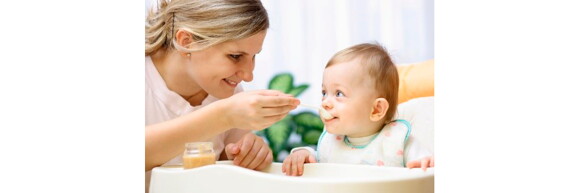 Mamá alimentando a su bebé en su silla