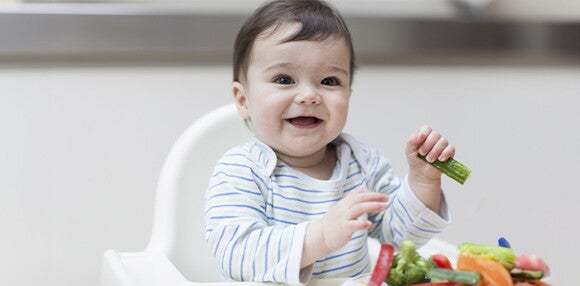 Enseña a tu bebé de 9 meses a comer alimentos sólidos Bebé de 9 meses cogiendo alimentos sólidos
