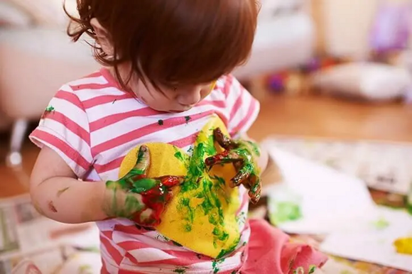Actividades sensoriales para niños de 12 a 24 meses niña jugando con pintura
