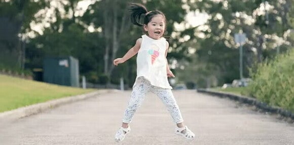 Saltar es una de las habilidades locomotrices más complejas Niña pequeña saltando al aire libre.