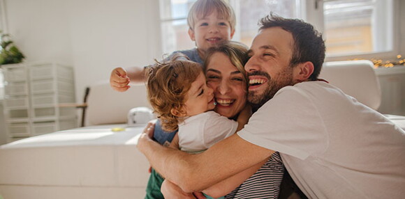 Papá y mamá abrazando a sus hijos.