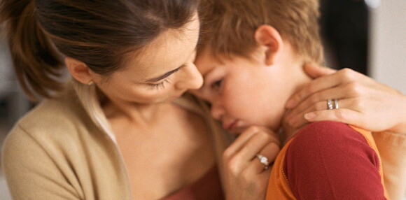 Mamá consolando a su hijo que está triste.