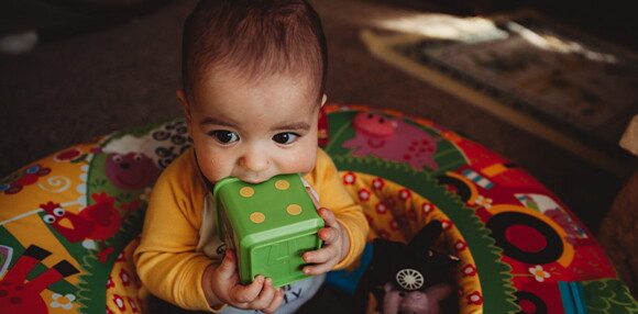 El juego estimula el desarrollo de tu bebé de 7 meses Bebé de 7 meses sentado jugando con sus juguetes
