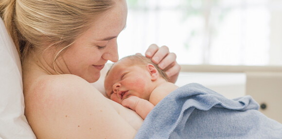 Existen varios motivos por los cuales el médico sugiere un parto inducido. Mamá teniendo a luz a su bebé por parto inducido.