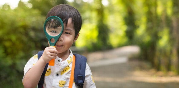 Existen varios tipos de estilos de aprendizaje. Niño con una lupa en la mano.